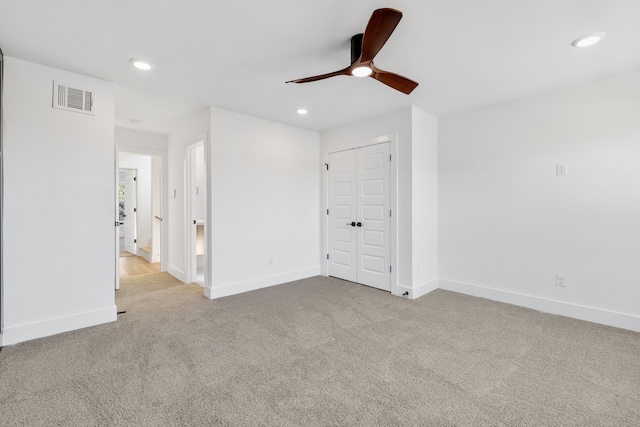 unfurnished bedroom featuring ceiling fan, light carpet, and a closet