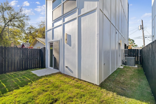 view of property exterior with a yard and central air condition unit