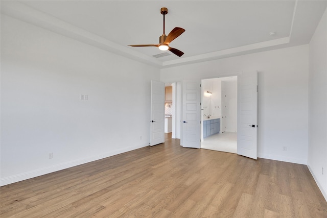 unfurnished bedroom featuring light wood-type flooring, ensuite bathroom, and ceiling fan