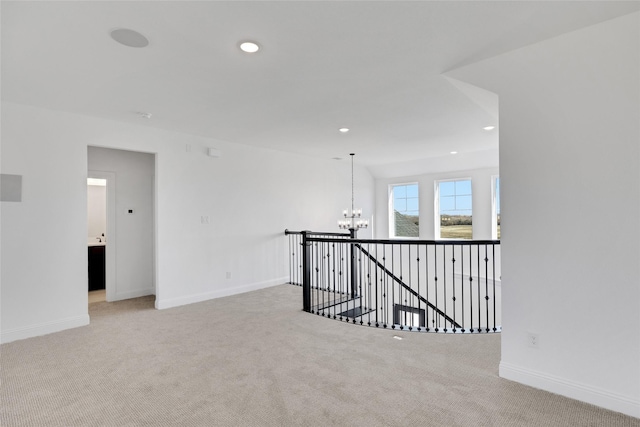 unfurnished room with light carpet and an inviting chandelier