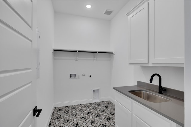 washroom with cabinets, sink, hookup for a washing machine, light tile patterned floors, and hookup for an electric dryer