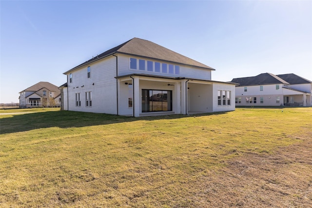 rear view of house featuring a yard