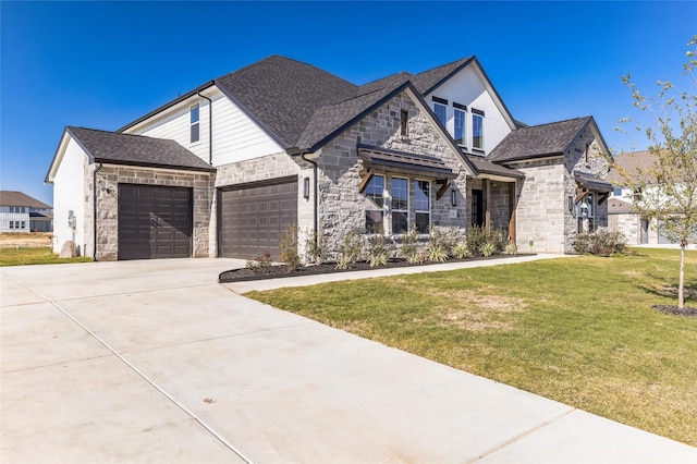 french country style house featuring a garage, a shingled roof, stone siding, concrete driveway, and a front yard