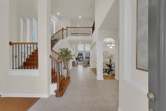 tiled entryway with a notable chandelier and ornate columns