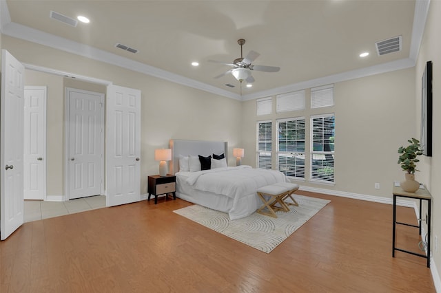 bedroom with ceiling fan, light wood-type flooring, and ornamental molding