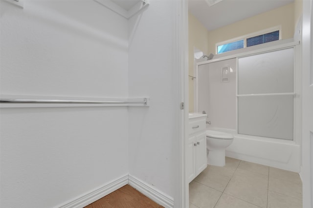 bathroom with shower / bath combination with glass door, tile patterned floors, and toilet