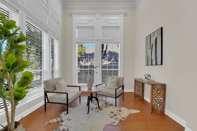 sitting room with light hardwood / wood-style flooring, a wealth of natural light, and crown molding