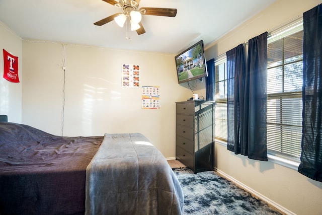 carpeted bedroom with ceiling fan and ornamental molding