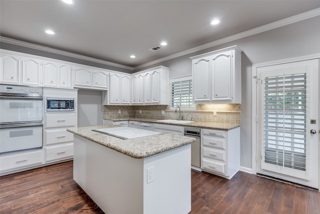 kitchen featuring a kitchen island, white appliances, sink, and white cabinetry