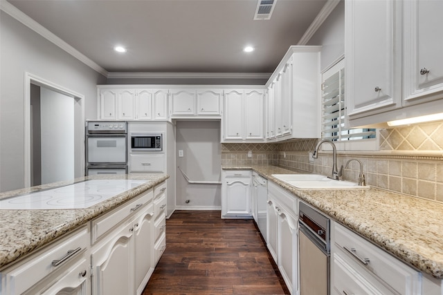 kitchen with sink, dark hardwood / wood-style floors, white cabinetry, stainless steel microwave, and white electric stovetop