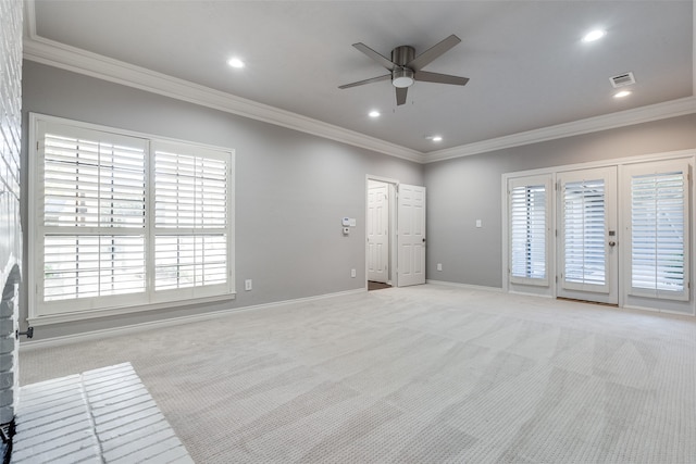 empty room featuring light carpet, crown molding, ceiling fan, and a healthy amount of sunlight