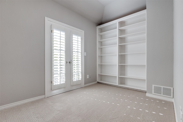 carpeted spare room featuring french doors