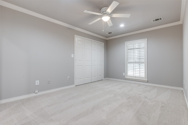 unfurnished bedroom featuring light carpet, a closet, ceiling fan, and ornamental molding