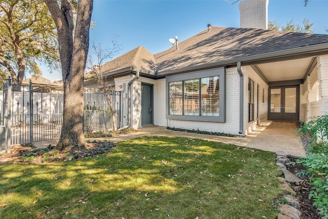 back of house with a lawn and french doors