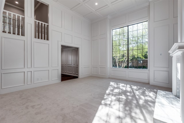 interior space with carpet flooring, plenty of natural light, and coffered ceiling