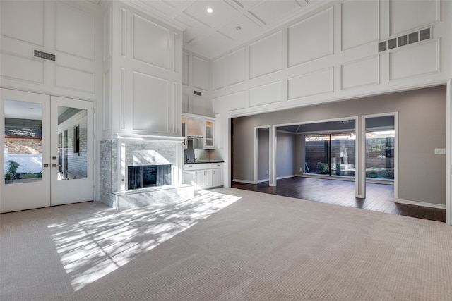 unfurnished living room featuring a high ceiling, dark hardwood / wood-style flooring, and french doors