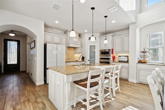 kitchen featuring a healthy amount of sunlight, sink, an island with sink, and stainless steel appliances