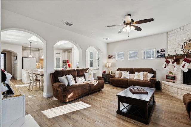 living room with light hardwood / wood-style floors and ceiling fan