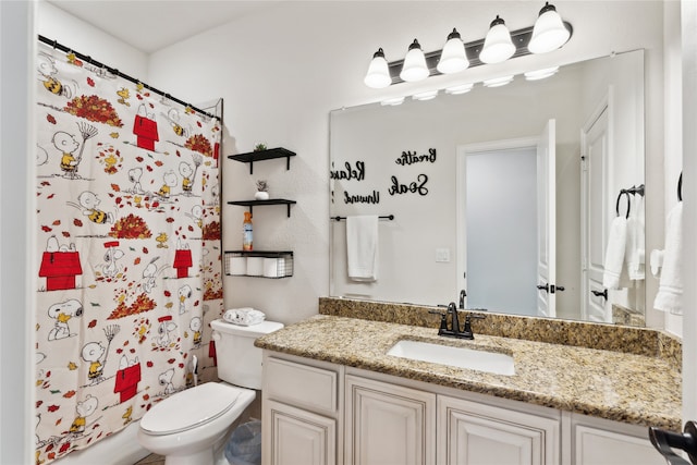 bathroom with vanity, a shower with shower curtain, and toilet