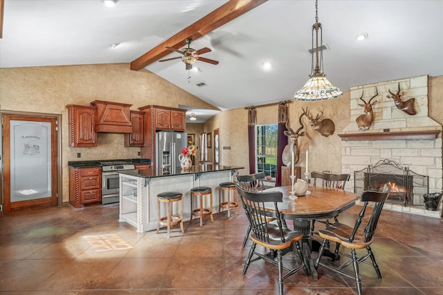 dining area featuring lofted ceiling with beams, ceiling fan, and a fireplace