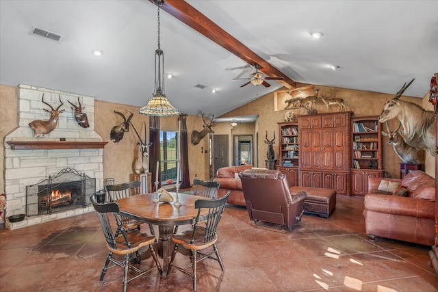 dining space featuring ceiling fan, a fireplace, and lofted ceiling with beams