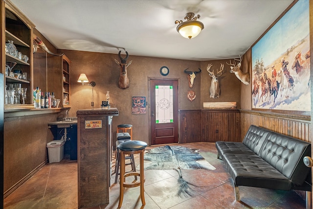 interior space featuring tile patterned flooring and wooden walls