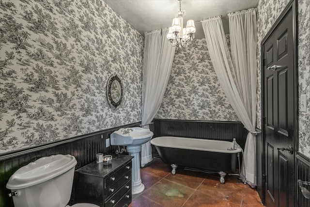 bathroom with an inviting chandelier, tile patterned flooring, a textured ceiling, toilet, and a bathtub