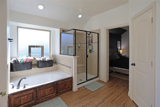 bathroom with hardwood / wood-style floors, shower with separate bathtub, and vaulted ceiling