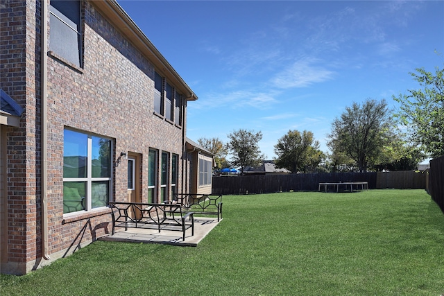 view of yard featuring a trampoline and a patio area