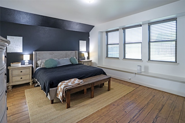 bedroom with hardwood / wood-style floors and lofted ceiling