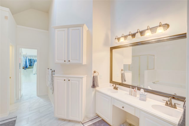 bathroom featuring high vaulted ceiling, a bathtub, and vanity