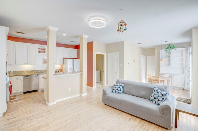 living room featuring light wood-type flooring and ornate columns