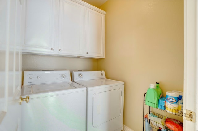 washroom featuring separate washer and dryer and cabinets