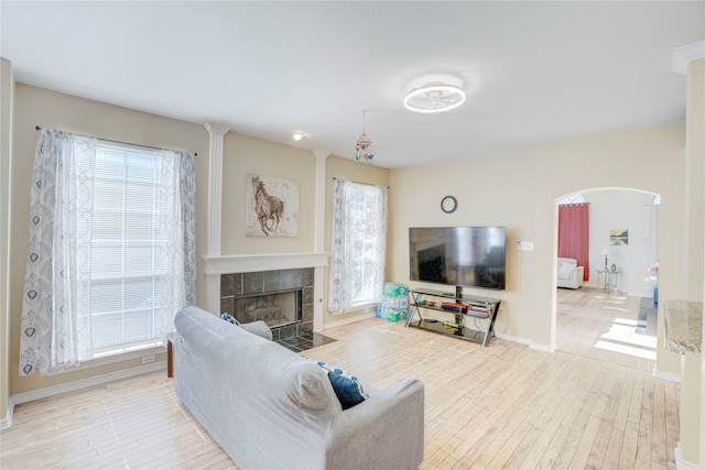 living room featuring a tile fireplace and light hardwood / wood-style floors