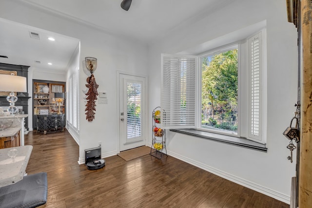 foyer entrance featuring crown molding and dark hardwood / wood-style floors