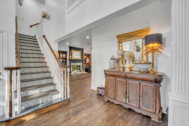 foyer entrance with dark hardwood / wood-style floors and a high ceiling