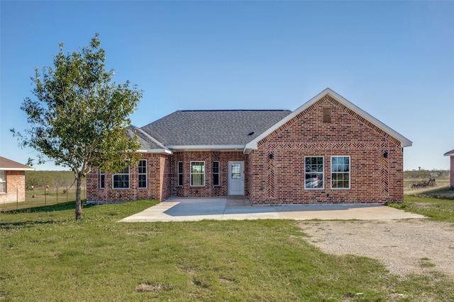 rear view of property featuring a lawn and a patio