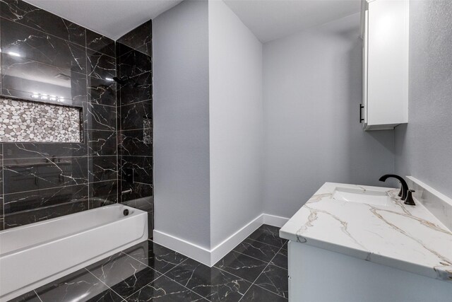 bathroom featuring vanity and tiled shower / bath