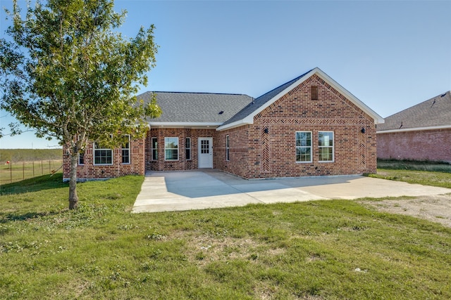 back of house with a patio and a lawn