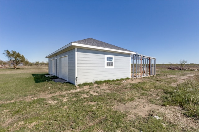 view of side of home with a yard and an outdoor structure