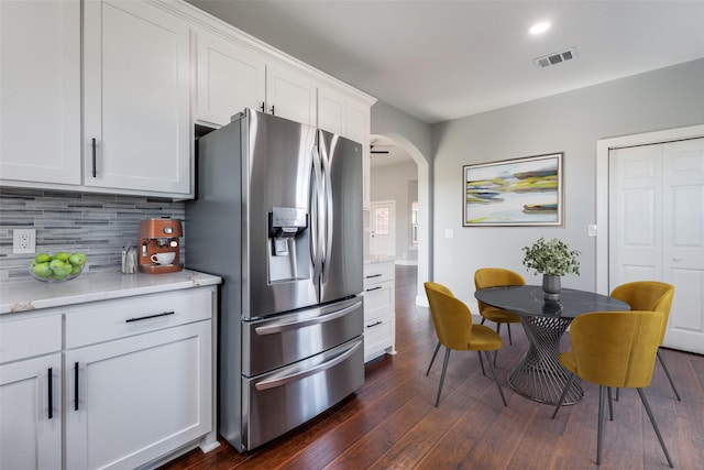 kitchen featuring white cabinets, stainless steel fridge with ice dispenser, dark hardwood / wood-style floors, and decorative backsplash