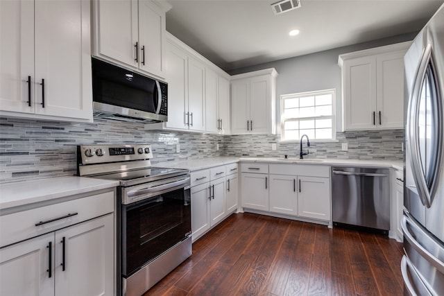 kitchen with dark hardwood / wood-style flooring, white cabinetry, and stainless steel appliances