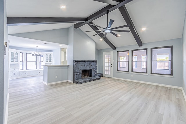 unfurnished living room featuring a fireplace, ceiling fan with notable chandelier, light hardwood / wood-style floors, and plenty of natural light