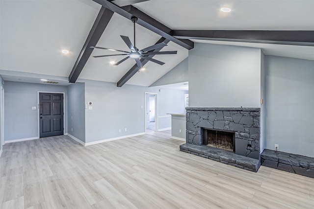 unfurnished living room with vaulted ceiling with beams, light hardwood / wood-style floors, a stone fireplace, and ceiling fan