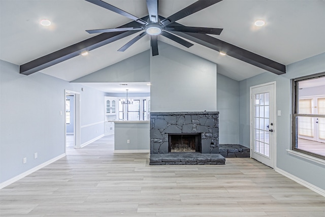 unfurnished living room with lofted ceiling with beams, a healthy amount of sunlight, and light wood-type flooring