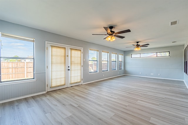 spare room featuring french doors, light hardwood / wood-style flooring, plenty of natural light, and ceiling fan