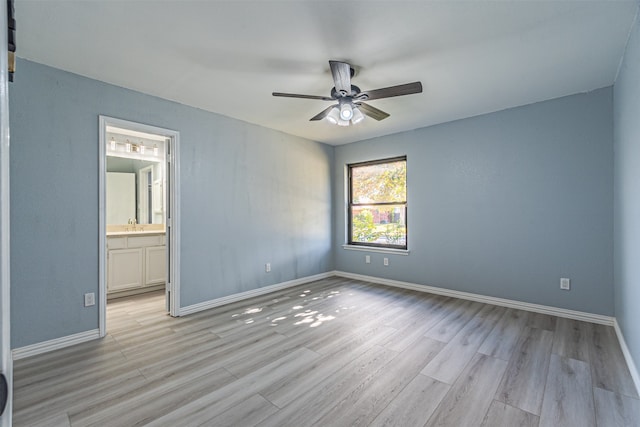 unfurnished bedroom featuring light wood-type flooring, ensuite bathroom, and ceiling fan