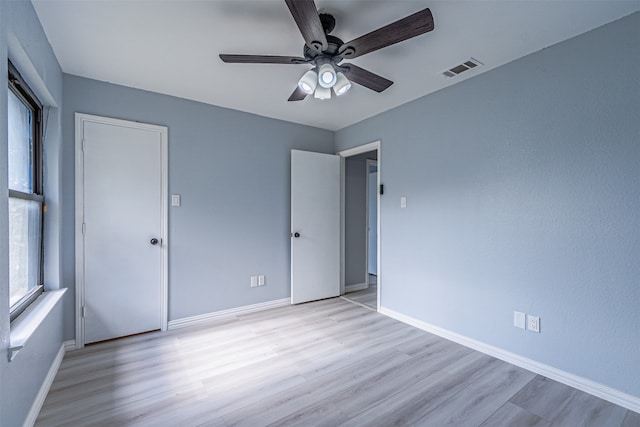 unfurnished bedroom featuring a closet, light hardwood / wood-style floors, and ceiling fan