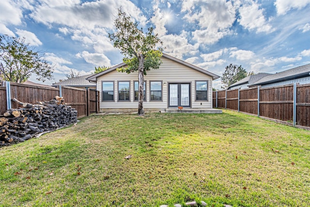 rear view of property featuring a lawn