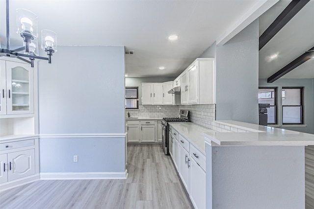 kitchen with white cabinetry, stainless steel gas range oven, backsplash, kitchen peninsula, and light wood-type flooring